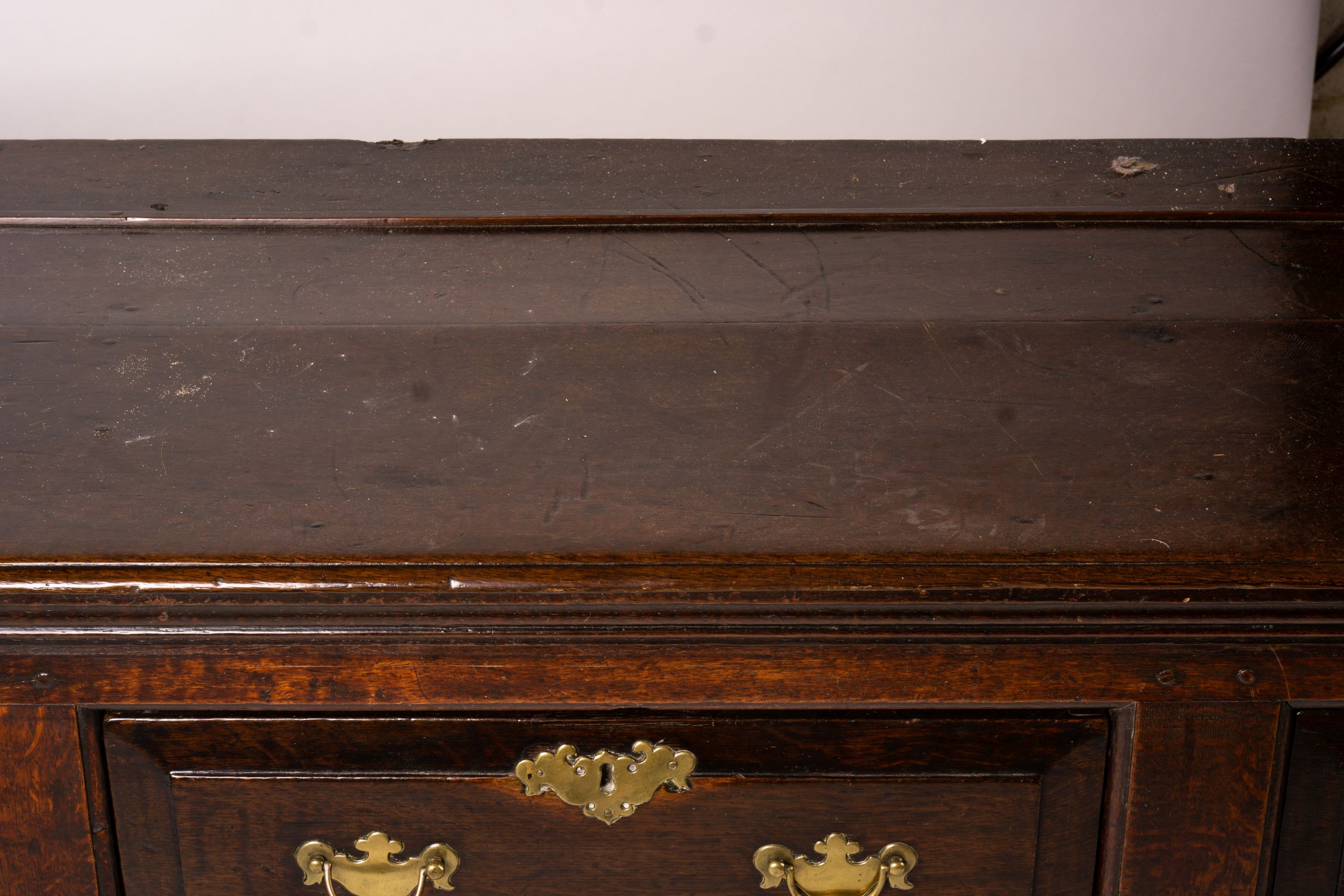 An 18th century oak low dresser on pole turned legs and pad feet, length 198cm, depth 53cm, height 88cm